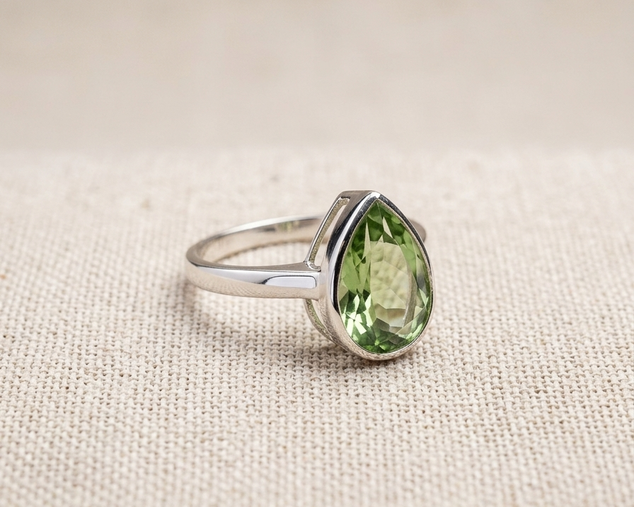 Side view of pear-cut green amethyst sterling silver ring in a modern bezel setting.