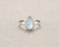 An elegant and minimalist teardrop-shaped natural moonstone ring in a polished sterling silver bezel setting.