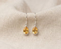 Faceted teardrop citrine drop earrings in 925 sterling silver bezel settings.