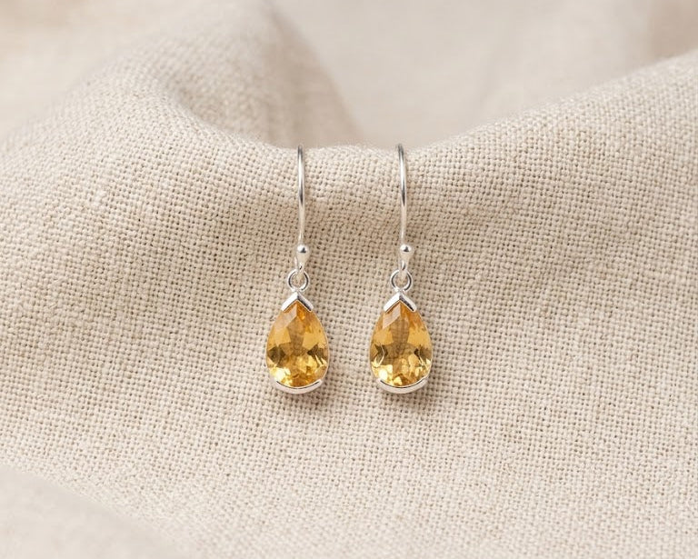 Faceted teardrop citrine drop earrings in 925 sterling silver bezel settings.