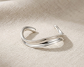 Sculptural sterling silver wide-wave bangle with a high-polished mirror finish.