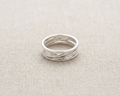 Alternate angle of the handcrafted high-polish .925 sterling silver multi-band 'interwoven' or 'twisted' design ring, set against a light, textured linen fabric background.